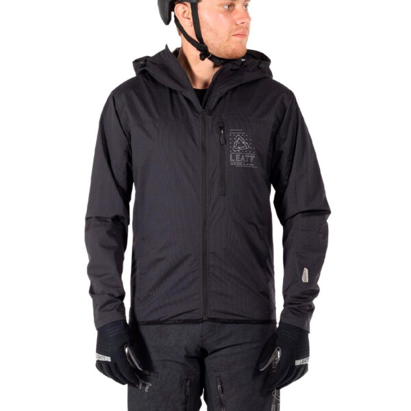 Rider modelando el cortaviento Leatt en vista frontal. Protección contra viento y estilo aerodinámico en acción MTB